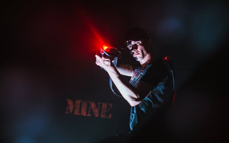 Mężczyzna celuje z karabinu na laser