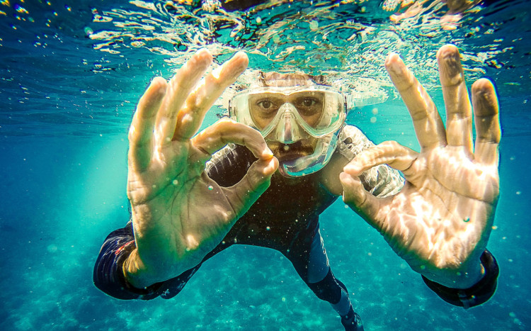mężczyzna pokazuje znak ok pod wodą